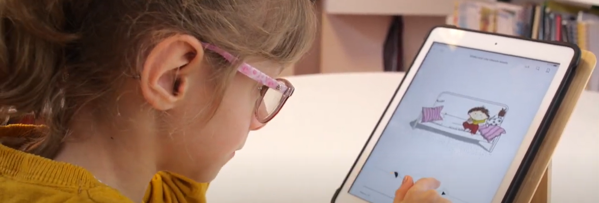 fille portant des lunettes qui lit le livre numérique emile veut une chauve-souris sur une tablette numérique